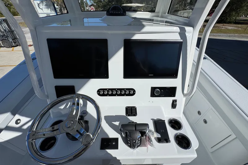 Slide: The Image of 2026 Yellowfin 36 Offshore boat dashboard with dual screens and steering wheel. - 36