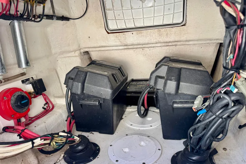 Slide: The Image of 2000 Contender 23 Open boat battery compartment with wiring and switches. - 12