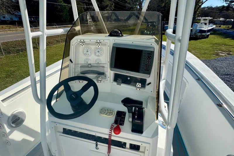 Slide: The Image of Center console of a 2000 Contender 23 Open boat with steering wheel and navigation equipment. - 8