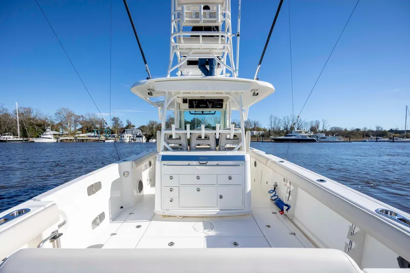 Slide: The Image of 2019 Boston Whaler 350 Outrage boat on calm water, showcasing spacious deck and seating. - 15