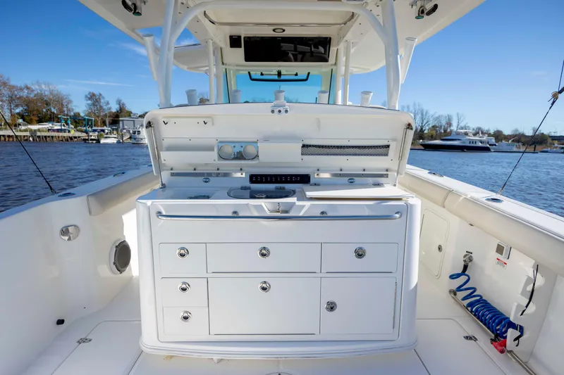 Slide: The Image of 2019 Boston Whaler 350 Outrage boat interior with storage and equipment, docked by the water. - 17