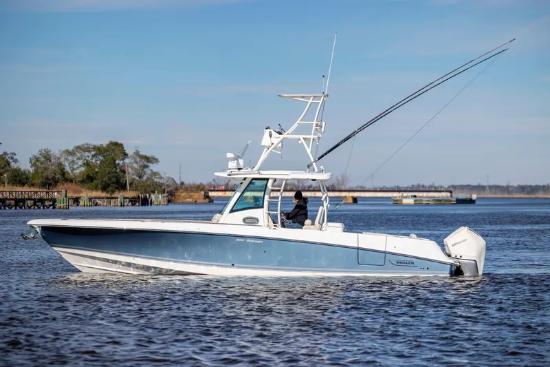 Slide: The Image of 2019 Boston Whaler 350 Outrage boat cruising on a calm river. - 2