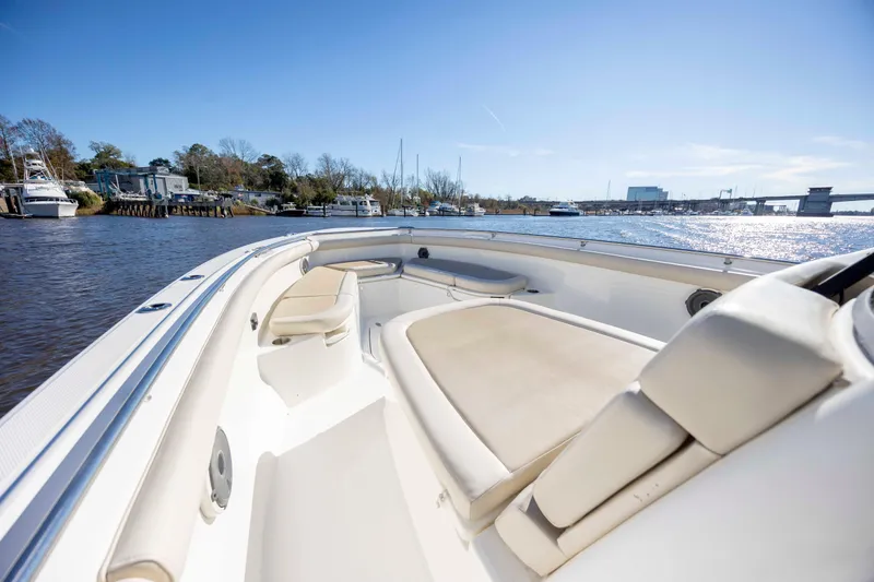 Slide: The Image of 2019 Boston Whaler 350 Outrage boat interior with seating, docked by a scenic waterfront. - 24