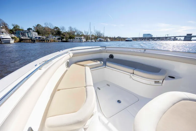 Slide: The Image of 2019 Boston Whaler 350 Outrage boat interior with cushioned seating on a sunny day. - 25