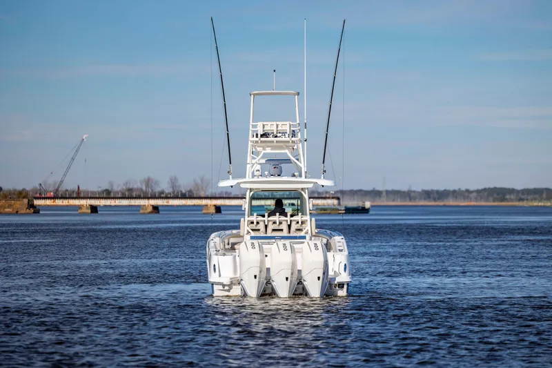 Slide: The Image of 2019 Boston Whaler 350 Outrage boat on calm water with bridge in background. - 4