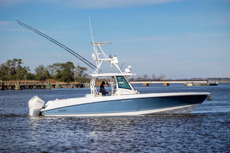 Slide: The Image of 2019 Boston Whaler 350 Outrage cruising on a calm river under a clear sky. - 6