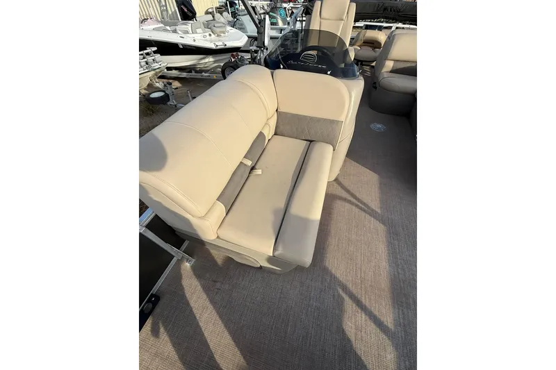 Slide: The Image of 2023 Sun Tracker Fishin' Barge 22 DLX interior with beige seating and cup holders. - 3