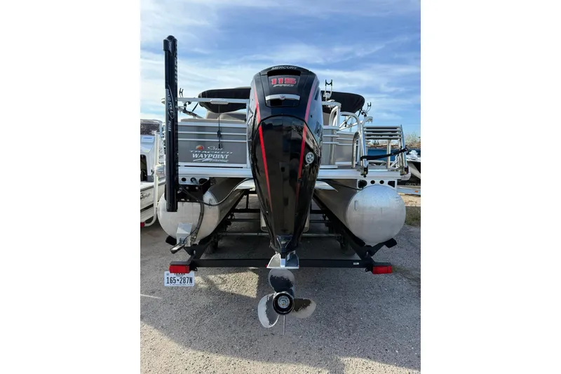 Slide: The Image of 2023 Sun Tracker Fishin' Barge 22 DLX interior with beige seating and fishing rod holders. - 7