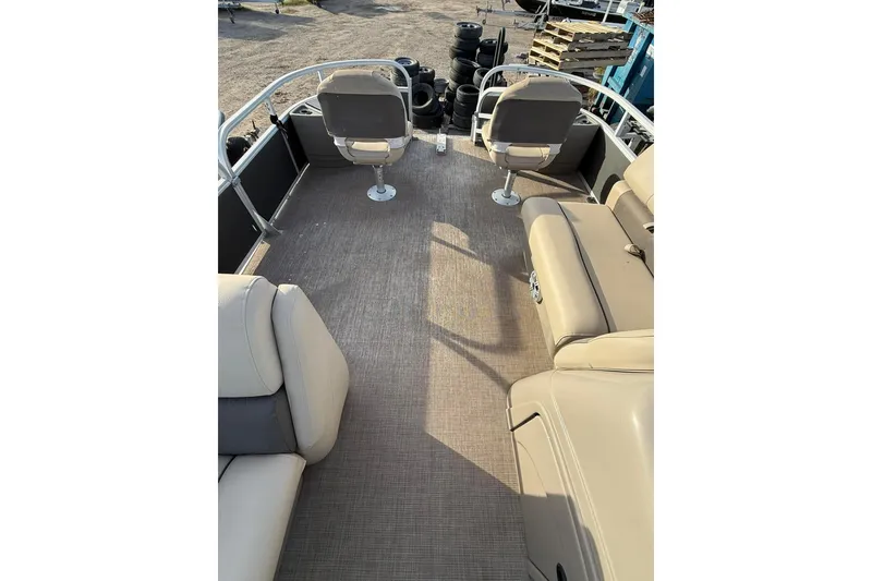 Slide: The Image of 2023 Sun Tracker Fishin' Barge 22 DLX interior with beige seating and carpeted floor. - 8