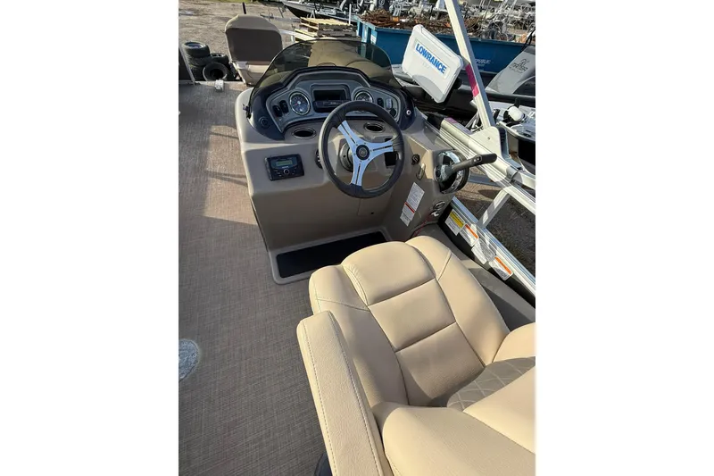 Slide: The Image of 2023 Sun Tracker Fishin' Barge 22 DLX interior with beige seating and spacious deck. - 9