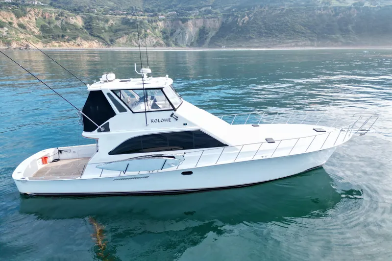 Slide: The Image of White 1993 Ocean 65 Custom yacht on calm water with scenic coastal backdrop. - 2