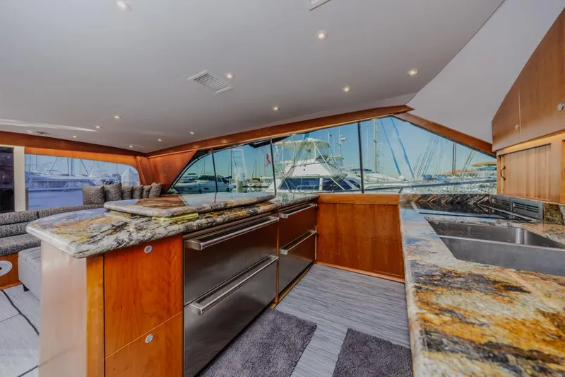 Slide: The Image of Luxurious interior of 1993 Ocean 65 Custom yacht with granite countertops and marina view. - 26