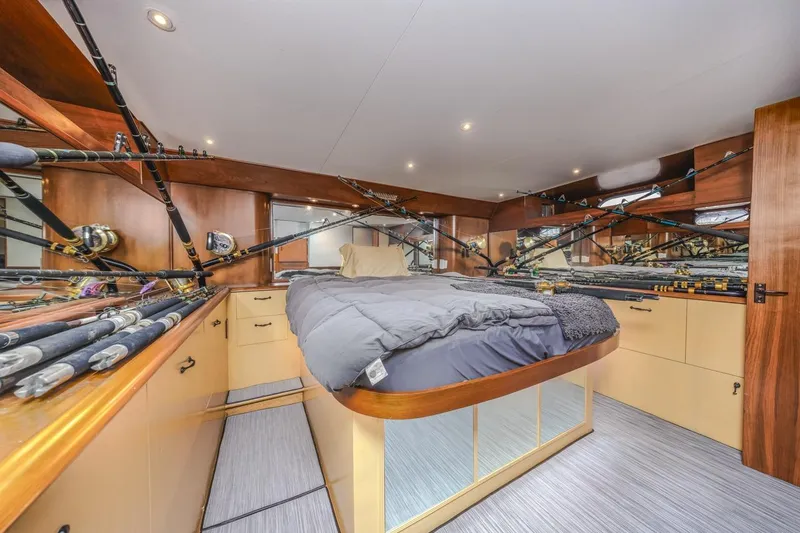 Slide: The Image of Luxurious 1993 Ocean 65 Custom yacht bedroom with fishing rods and elegant wood finish. - 30