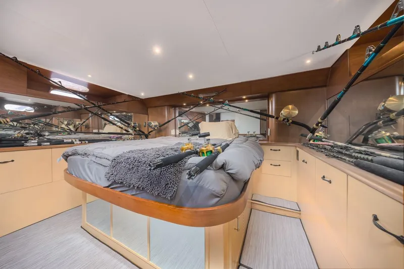 Slide: The Image of Luxurious 1993 Ocean 65 Custom yacht bedroom with fishing rods and elegant wood cabinetry. - 31