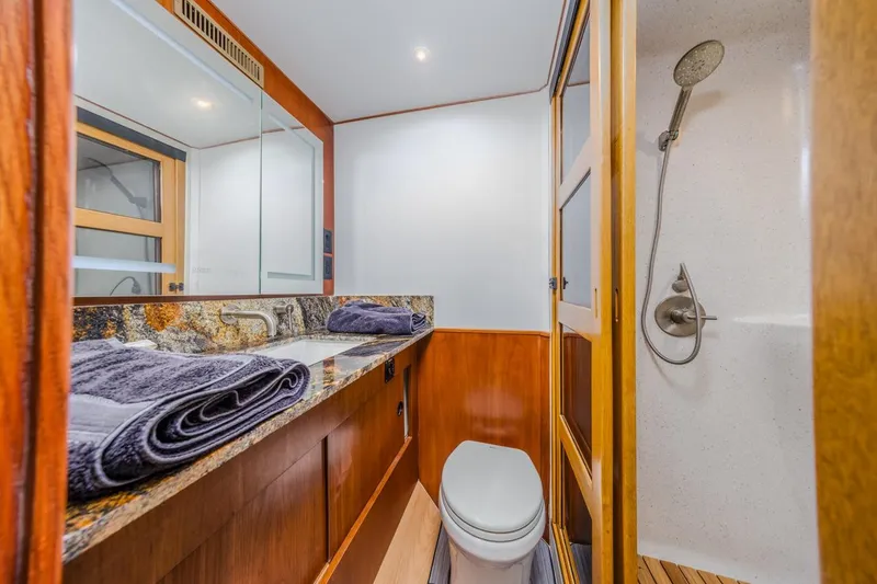 Slide: The Image of Luxurious bathroom in 1993 Ocean 65 Custom yacht with granite countertop and shower. - 32
