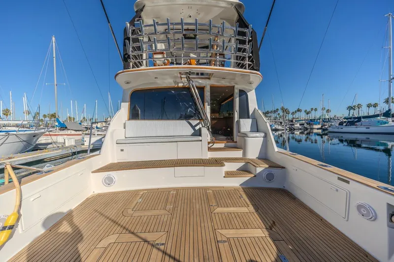 Slide: The Image of 1993 Ocean 65 Custom yacht with spacious deck, docked in a marina under clear blue skies. - 7