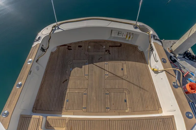Slide: The Image of 1993 Ocean 65 Custom yacht deck with teak flooring and mooring lines. - 8