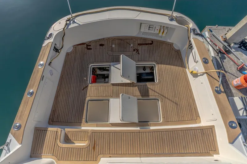 Slide: The Image of 1993 Ocean 65 Custom yacht deck with open storage compartments, docked at marina. - 9