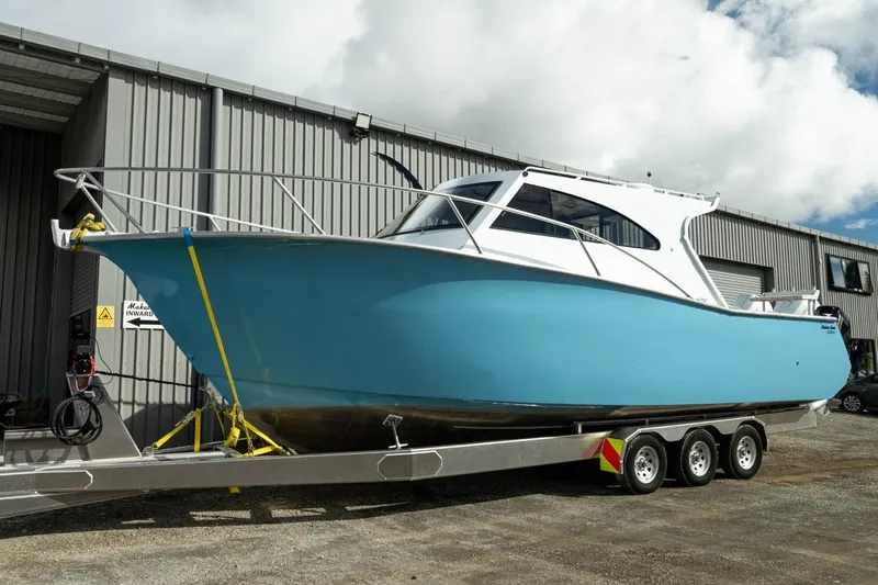 The Image of 2025 Makaira Gen 3 36 boat on trailer outside industrial building. - 1