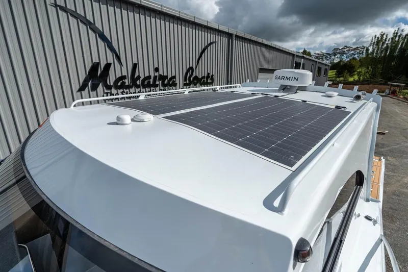 Slide: The Image of 2025 Makaira Gen 3 36 boat with solar panels and Garmin equipment, docked near Makaira Boats building. - 14