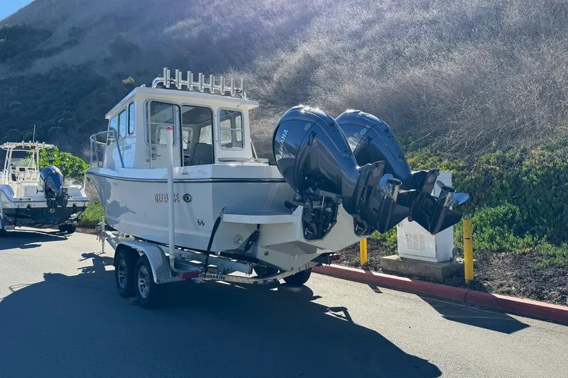 Slide: The Image of 2026 Defiance Admiral 250 EX boat on trailer, dual outboard motors, parked roadside. - 10