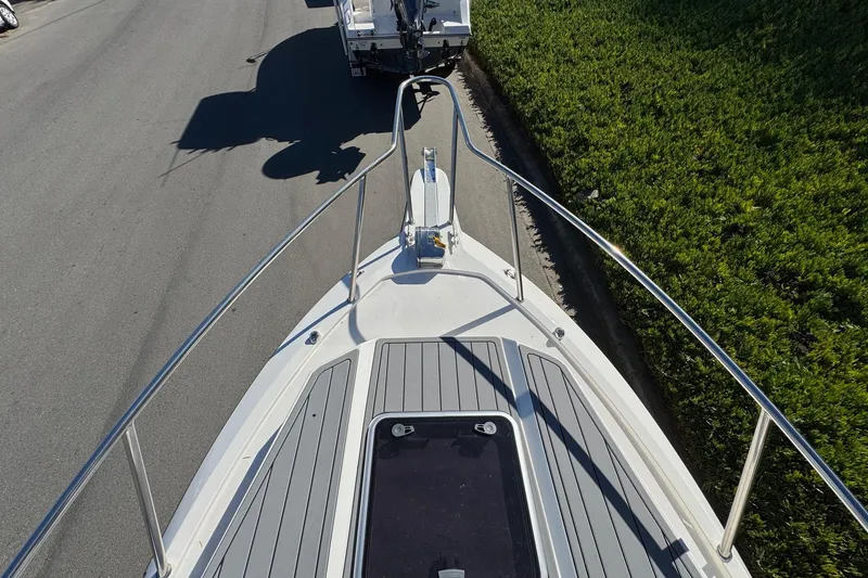 Slide: The Image of 2026 Defiance Admiral 250 EX boat on trailer, viewed from above, near greenery. - 101