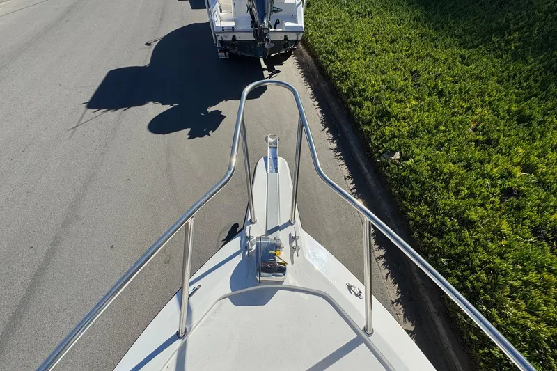 Slide: The Image of Bow view of 2026 Defiance Admiral 250 EX boat on trailer, near greenery. - 102