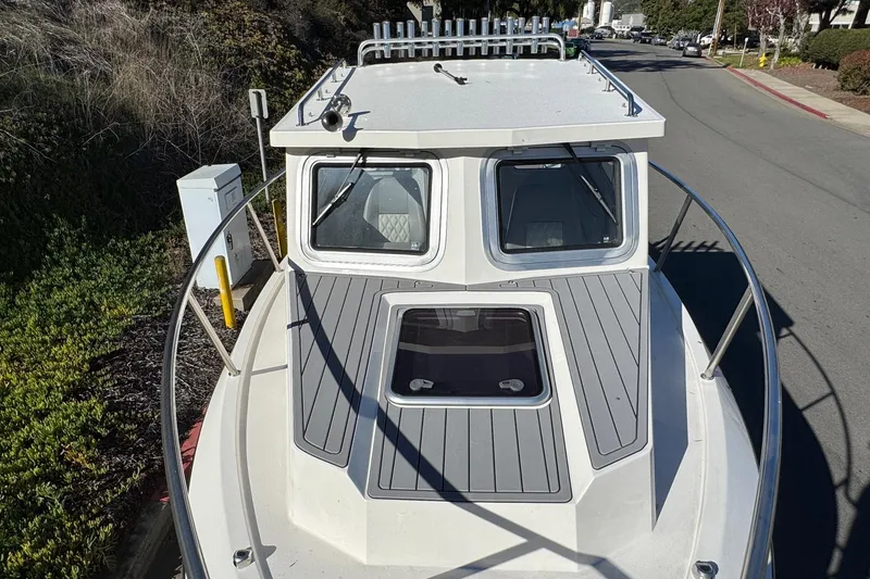 Slide: The Image of 2026 Defiance Admiral 250 EX boat on a street, showcasing its deck and cabin. - 104