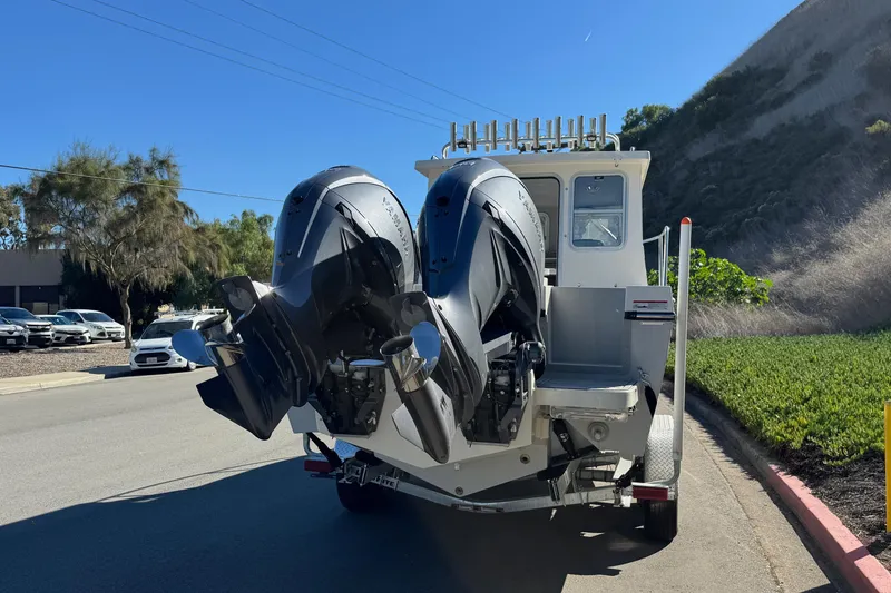 Slide: The Image of 2026 Defiance Admiral 250 EX boat with dual outboard motors on a trailer. - 13