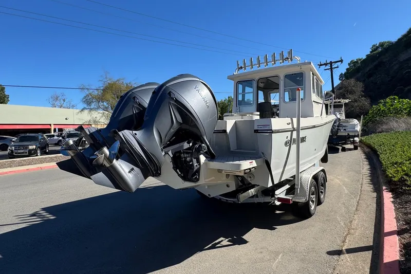 Slide: The Image of 2026 Defiance Admiral 250 EX boat on trailer, dual outboard motors, parked on roadside. - 14