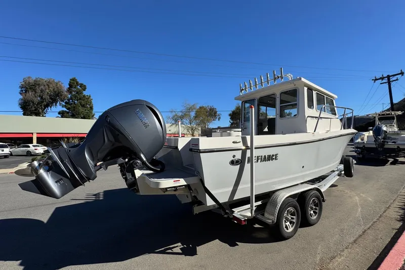 Slide: The Image of 2026 Defiance Admiral 250 EX boat on trailer, parked outdoors under clear blue sky. - 15