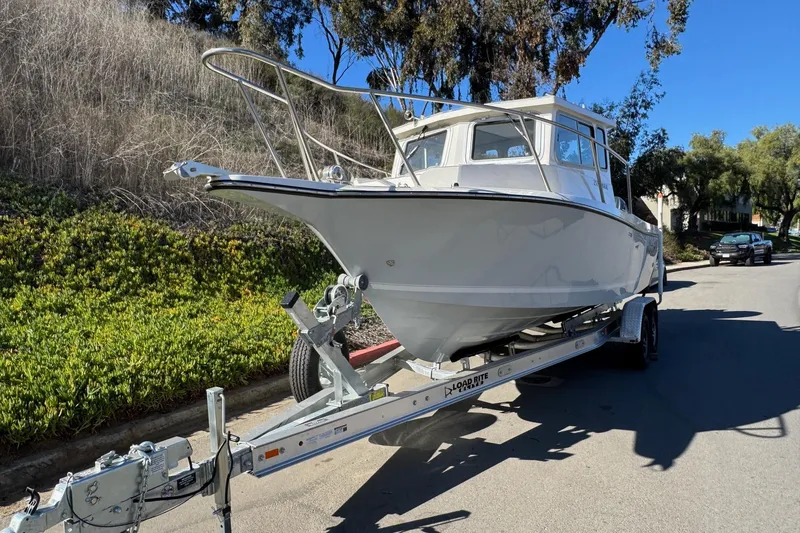Slide: The Image of 2026 Defiance Admiral 250 EX boat on trailer, parked on a sunny street. - 21