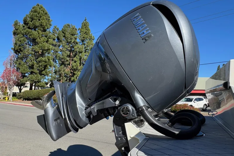 Slide: The Image of 2026 Defiance Admiral 250 EX with Yamaha outboard motor, parked outdoors. - 24