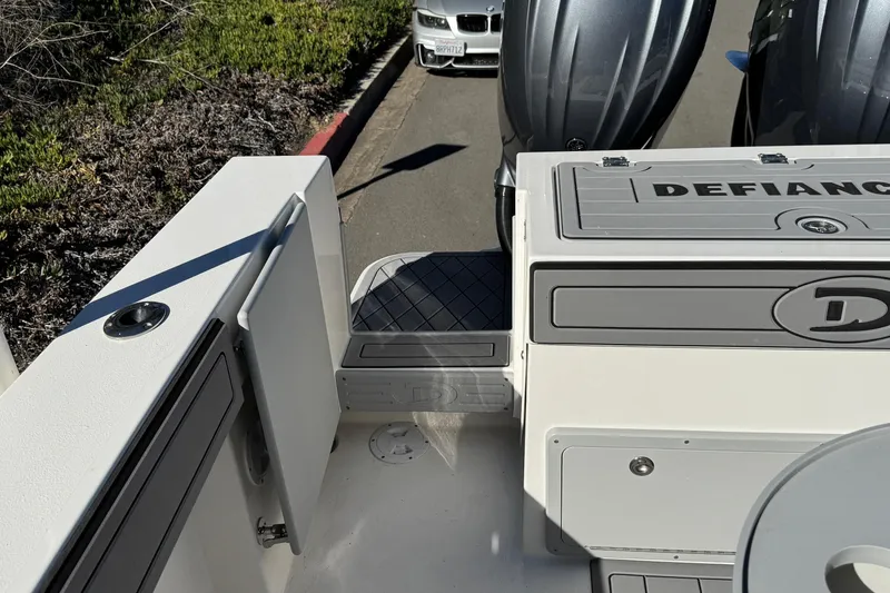 Slide: The Image of 2026 Defiance Admiral 250 EX boat interior with dual engines, parked near a road. - 30