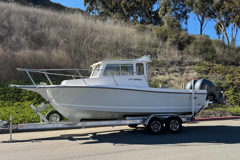 Slide: The Image of 2026 Defiance Admiral 250 EX boat on trailer, parked outdoors. - 4