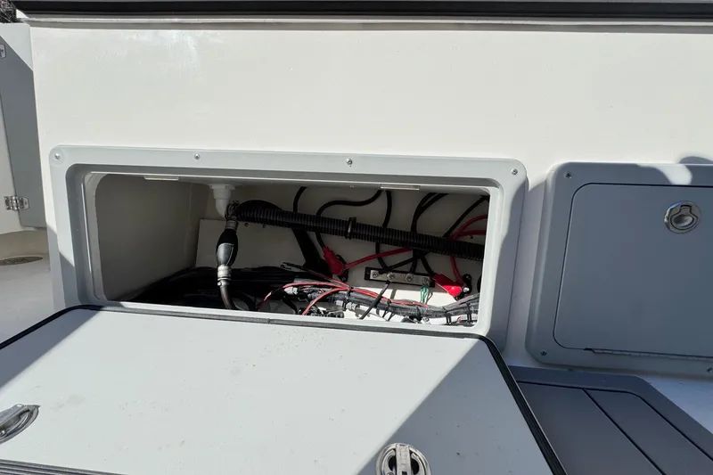 Slide: The Image of Open compartment of 2026 Defiance Admiral 250 EX boat showing wiring and cables. - 44