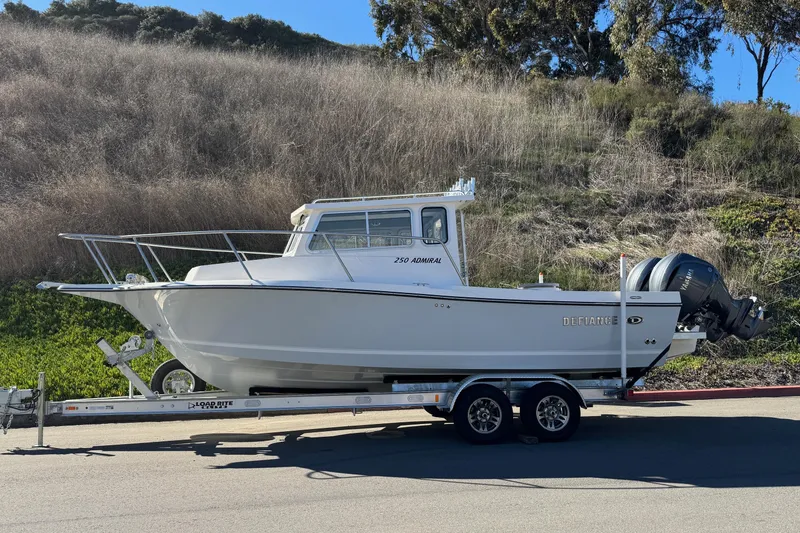 Slide: The Image of 2026 Defiance Admiral 250 EX boat on trailer, parked outdoors. - 5