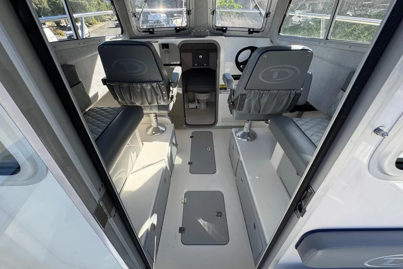 Slide: The Image of Interior of 2026 Defiance Admiral 250 EX boat, featuring seating and steering area. - 50