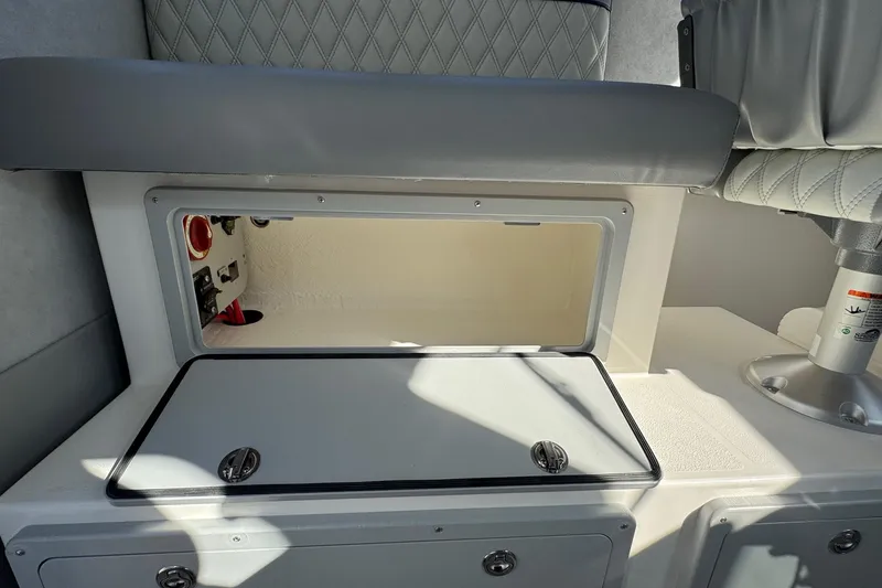 Slide: The Image of Storage compartment in 2026 Defiance Admiral 250 EX boat interior, featuring cushioned seating. - 53