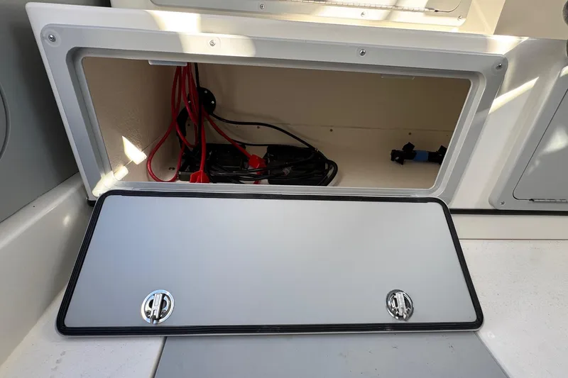 Slide: The Image of Open storage compartment on 2026 Defiance Admiral 250 EX boat, showing interior wiring. - 56