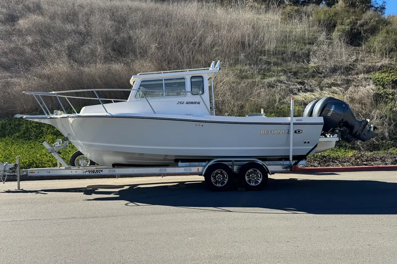 Slide: The Image of 2026 Defiance Admiral 250 EX boat on trailer, parked outdoors. - 6
