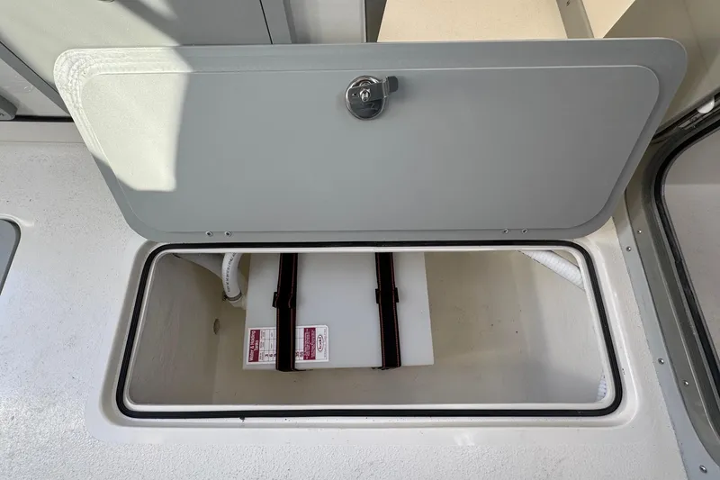 Slide: The Image of Open storage compartment on 2026 Defiance Admiral 250 EX boat. - 62