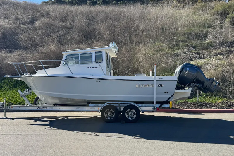 Slide: The Image of 2026 Defiance Admiral 250 EX boat on trailer, parked outdoors. - 7