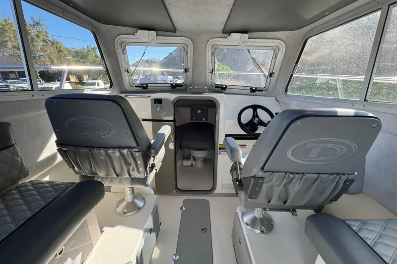 Slide: The Image of Interior of 2026 Defiance Admiral 250 EX boat, featuring helm and seating area. - 70