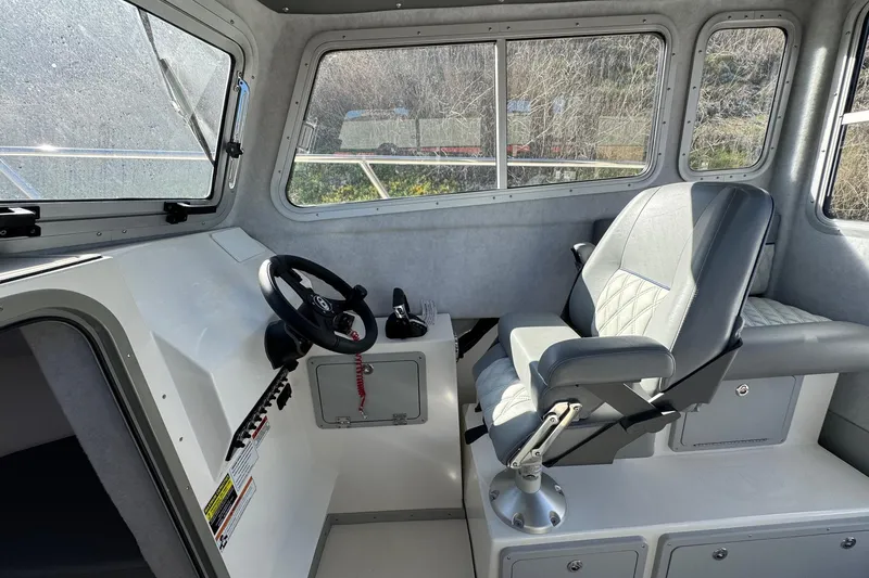 Slide: The Image of Interior of 2026 Defiance Admiral 250 EX boat, featuring steering wheel and captain's chair. - 71