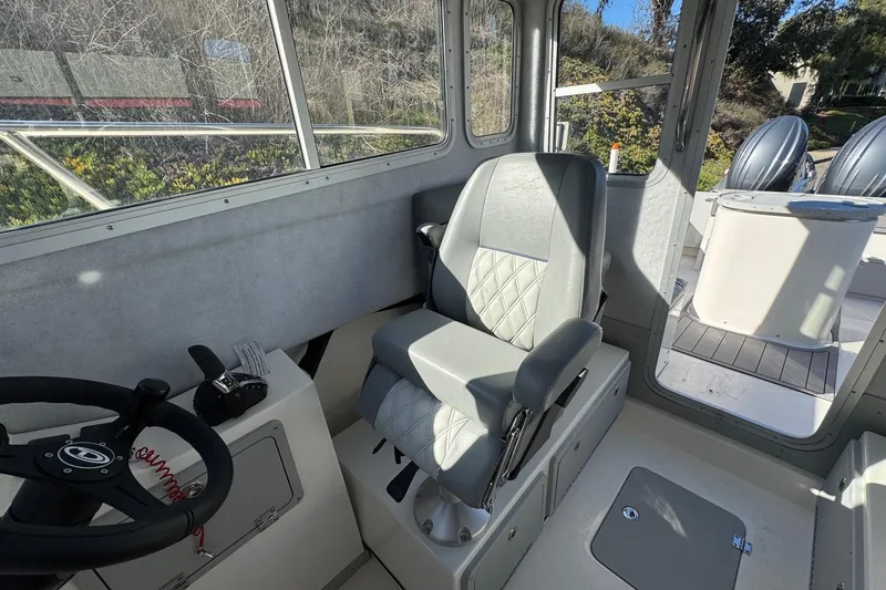 Slide: The Image of Interior of 2026 Defiance Admiral 250 EX boat with steering wheel and captain's chair. - 72