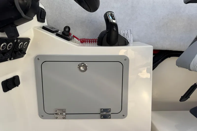 Slide: The Image of 2026 Defiance Admiral 250 EX boat console with control panel and storage compartment. - 77