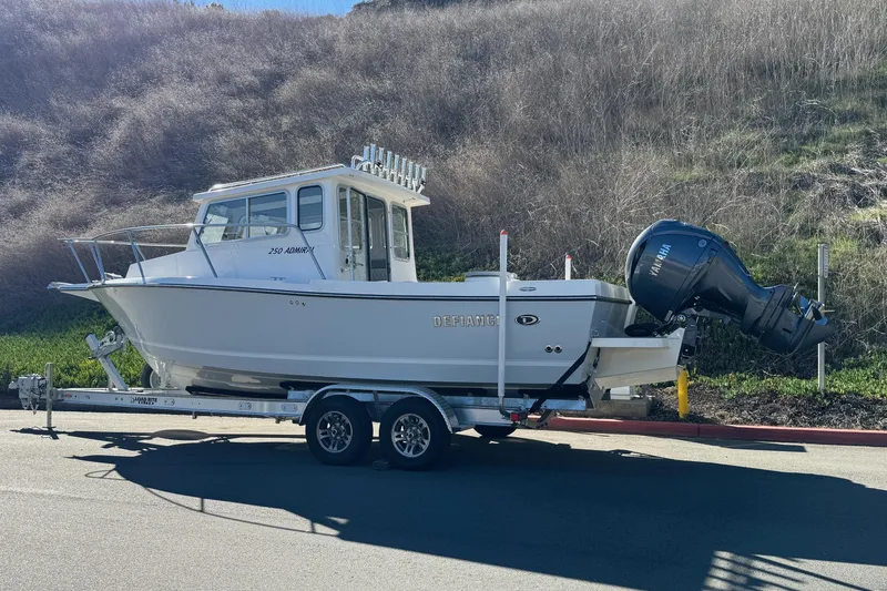 Slide: The Image of 2026 Defiance Admiral 250 EX boat on trailer, parked on roadside. - 8