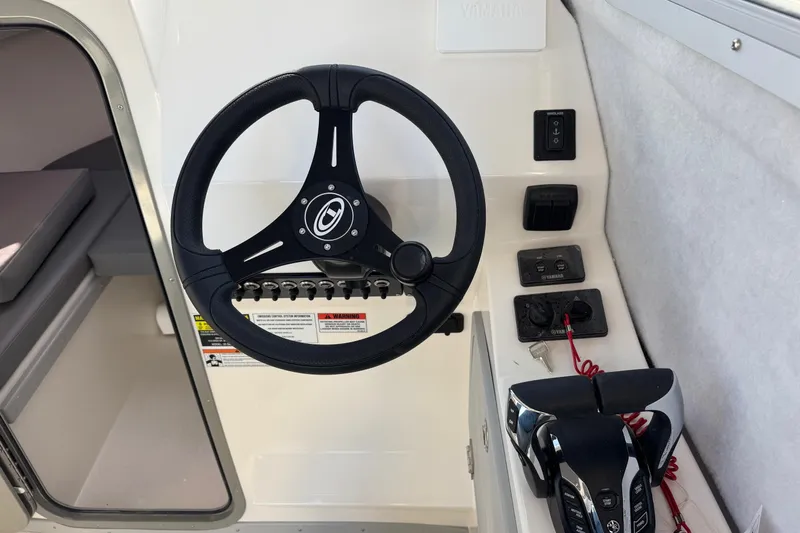 Slide: The Image of Steering wheel and controls of 2026 Defiance Admiral 250 EX boat cockpit. - 80