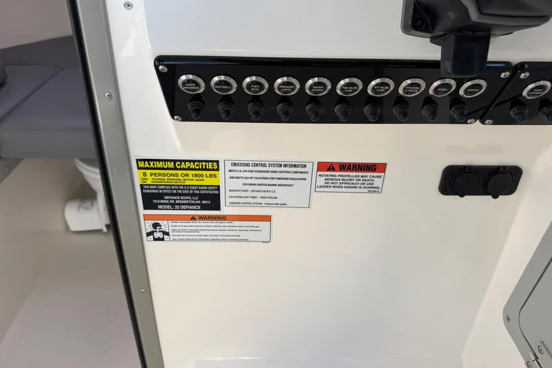 Slide: The Image of Control panel of 2026 Defiance Admiral 250 EX boat with capacity and warning labels. - 82